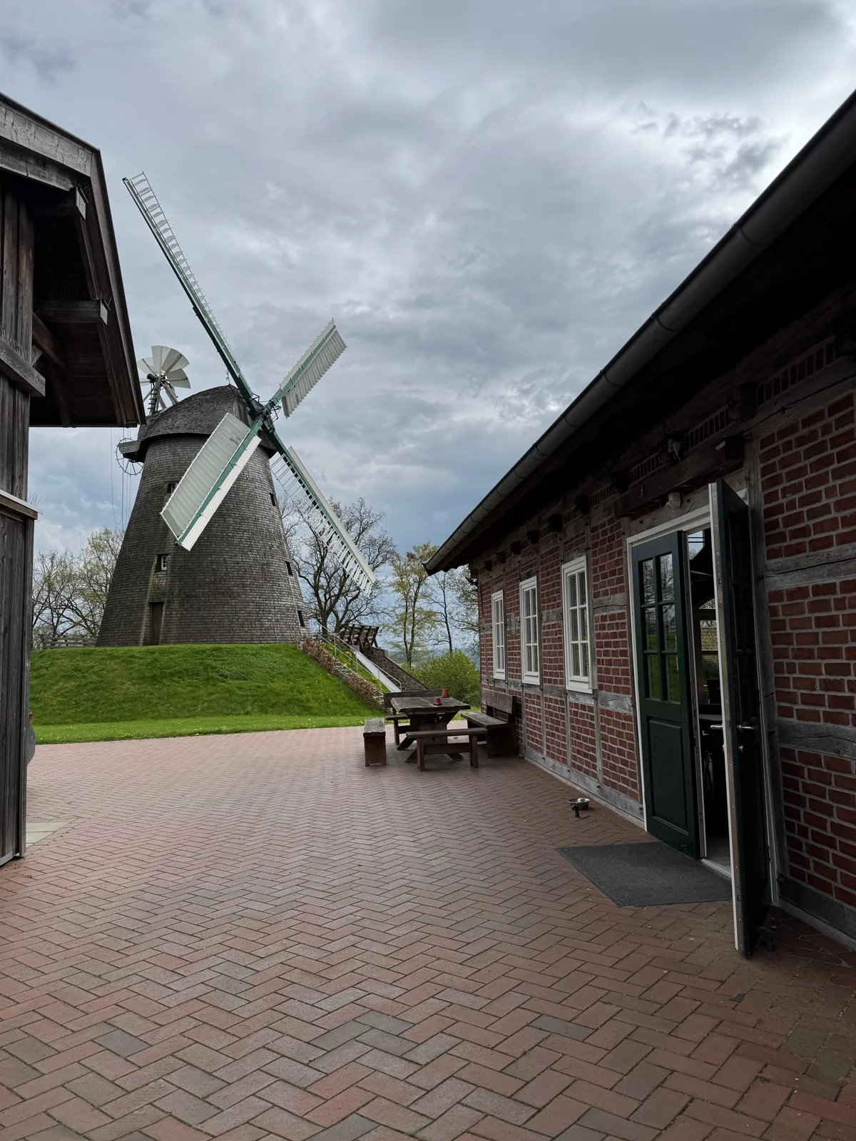 Blick über den Innenhof auf die historische Windmühle Exter und das angrenzende Fachwerkgebäude.