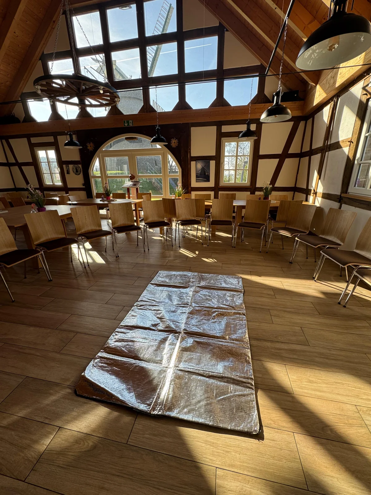 Vorbereiteter Kursraum mit Stuhlkreis und Übungsmatte im Fachwerkgebäude an der Windmühle Exter.