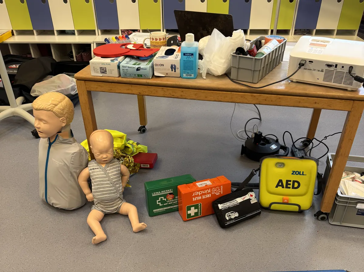 Trainingsmaterial mit Baby- und Kinderphantom, Verbandkästen und AED-Trainer.