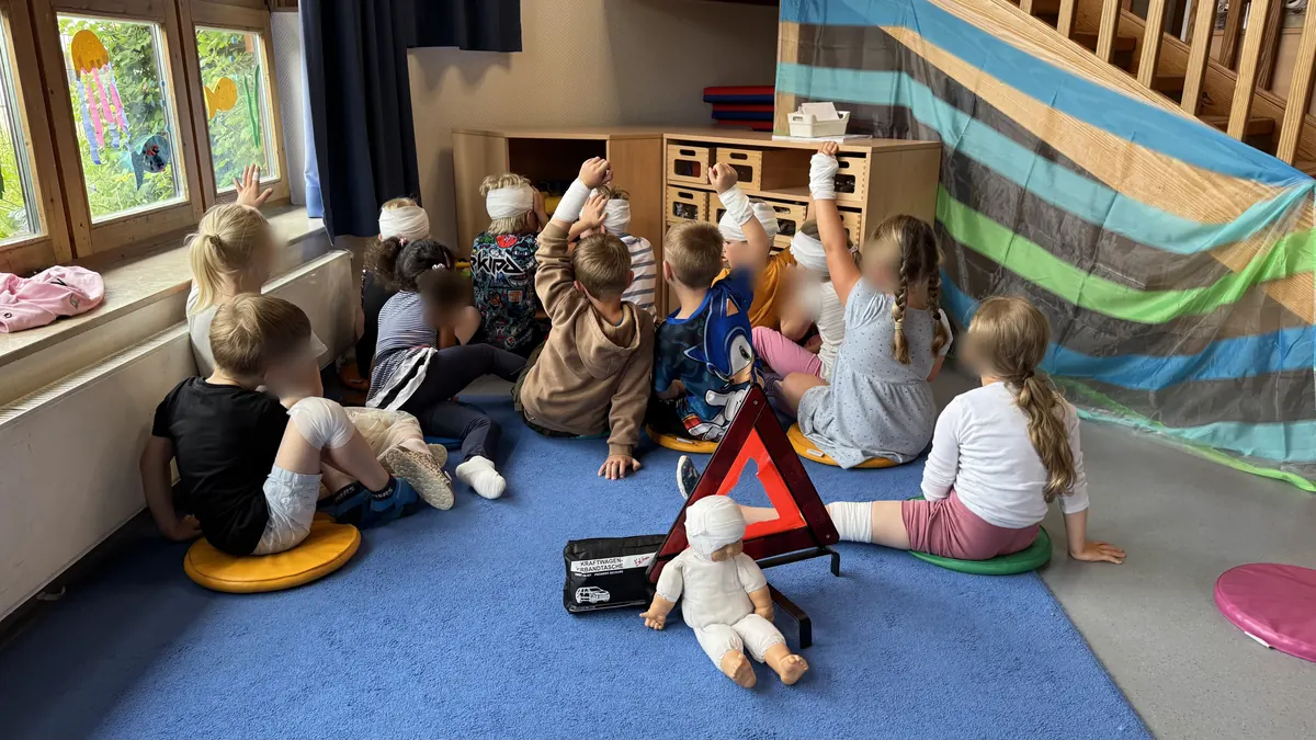 Kinder üben gemeinsam mit Verbänden und Erste-Hilfe-Trainingsmaterial.