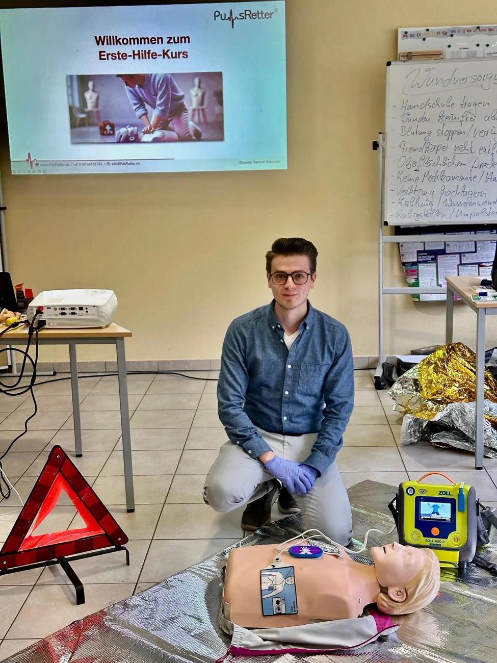Samuel Schindler beim Erste-Hilfe-Training mit Reanimationsmodell und AED