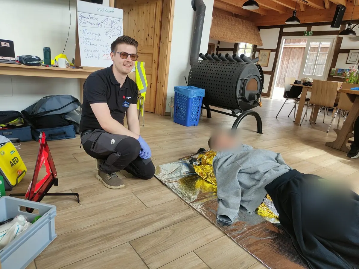 Samuel Schindler begleitet eine praktische Übung zum Wärmeerhalt mit einer Rettungsdecke.